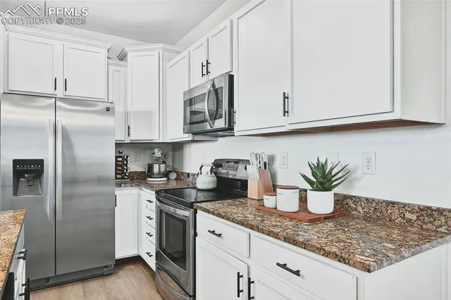 a kitchen with stainless steel appliances kitchen island granite countertop a refrigerator a stove and a sink