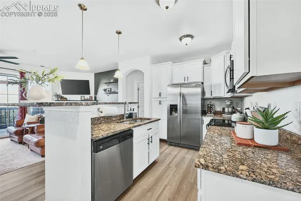 a living room with kitchen island furniture and a chandelier