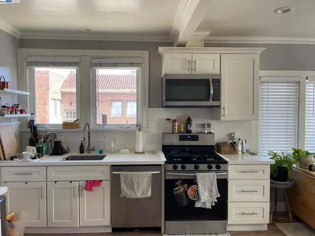 a kitchen with kitchen island granite countertop a sink cabinets and stainless steel appliances
