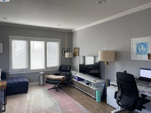 a living room with furniture a flat screen tv and a window