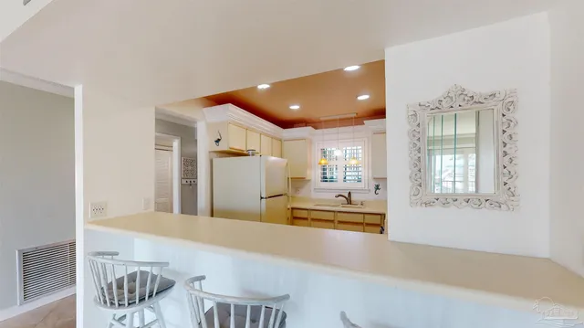 a kitchen with stainless steel appliances kitchen island granite countertop a refrigerator and a sink