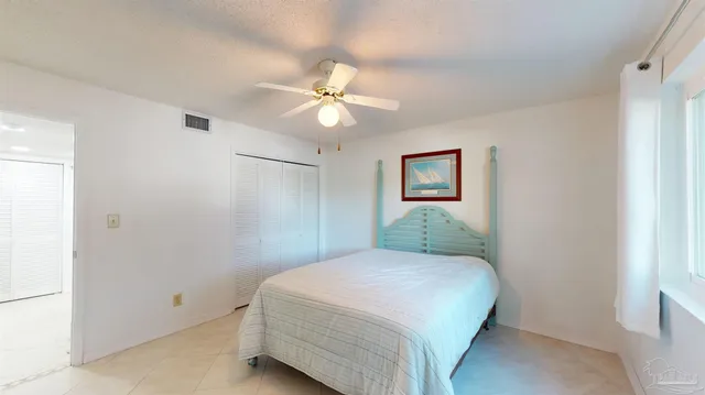a bedroom with a large bed and a ceiling fan