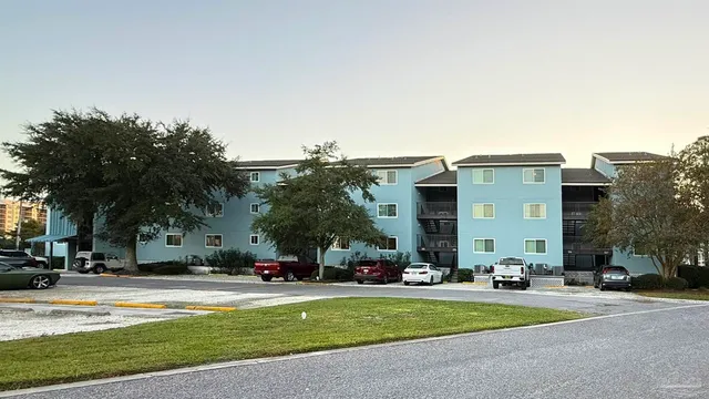 a view of a fountain with a big yard and large trees