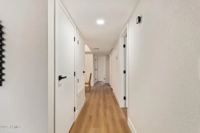 a view of a hallway with wooden floor and staircase