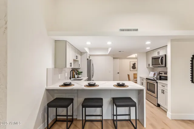 a kitchen with white cabinets stainless steel appliances and sink