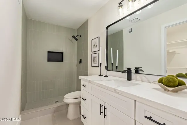 a bathroom with a granite countertop sink a toilet and shower