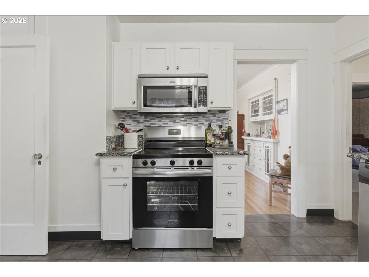 706 West B Street Rainier, OR 97048 - Photo 13 of 47 a kitchen with stainless steel appliances a stove and a microwave