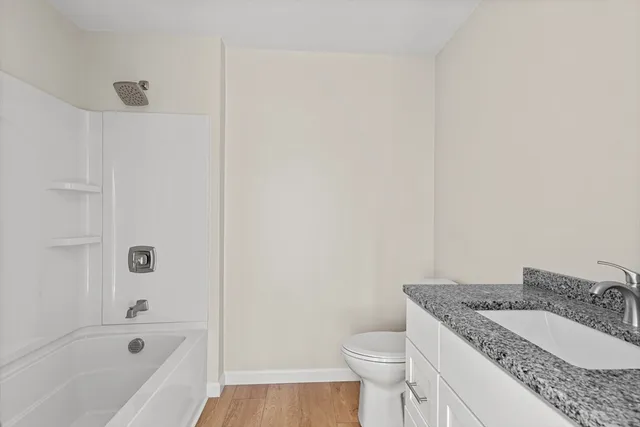 a bathroom with a granite countertop sink toilet and bathtub