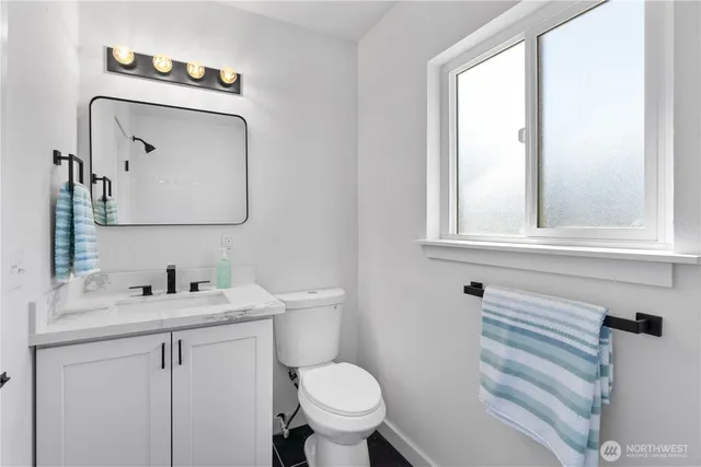 a bathroom with a toilet sink and mirror