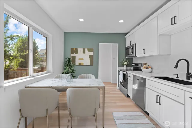 a kitchen with stainless steel appliances granite countertop a refrigerator a sink dishwasher and white cabinets with wooden floor