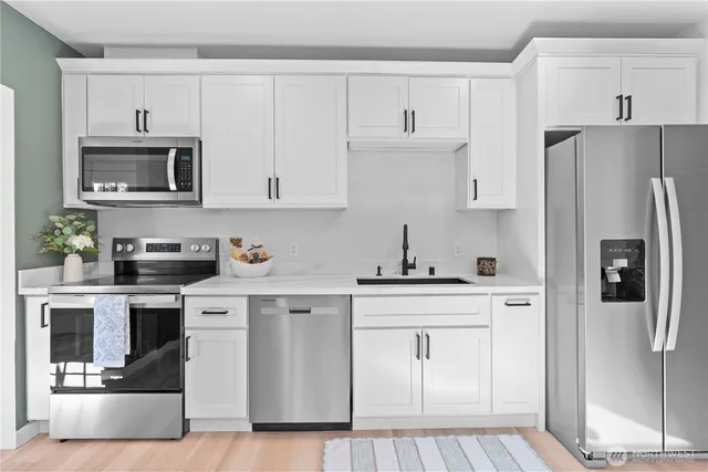 a kitchen with cabinets stainless steel appliances and a counter space