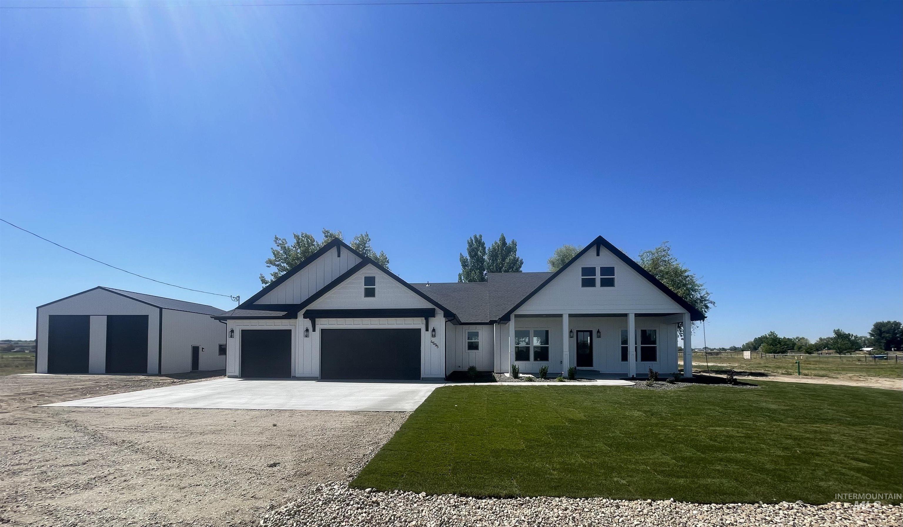 Modern farmhouse style home with concrete driveway, an attached garage, covered porch, and a front lawn