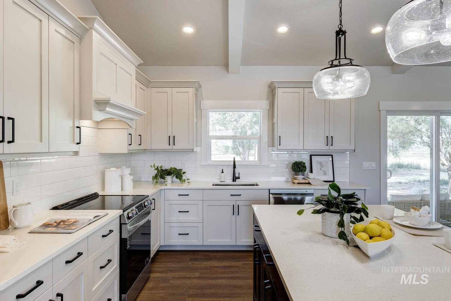 4695 County Line Road New Plymouth, ID 83655 - Photo 14 of 49 Kitchen with appliances with stainless steel finishes, light countertops, dark wood-type flooring, beam ceiling, and hanging light fixtures