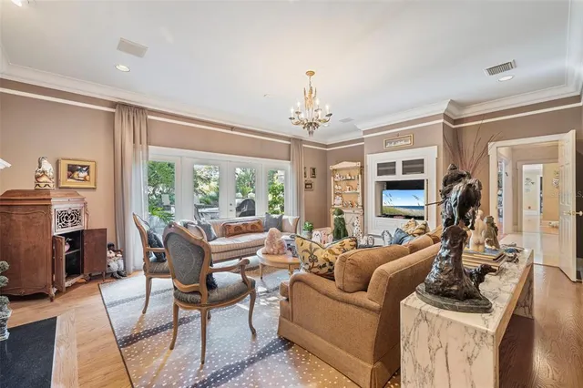 a view of a dining room and livingroom with furniture wooden floor a chandelier