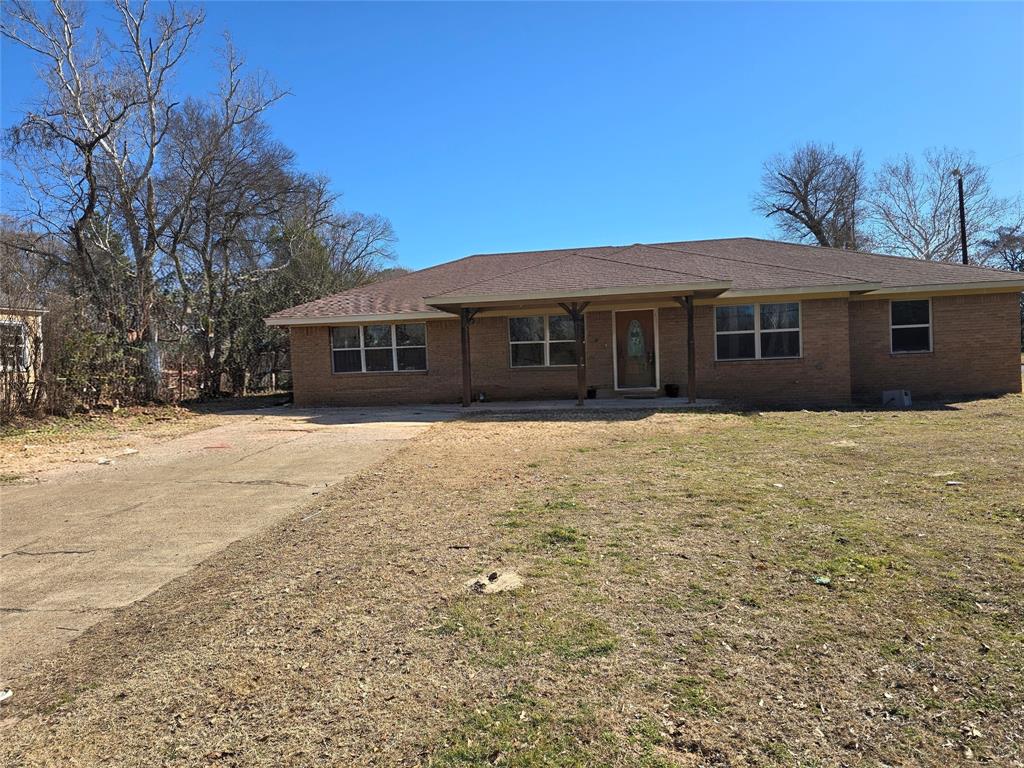a front view of house with yard and trees around