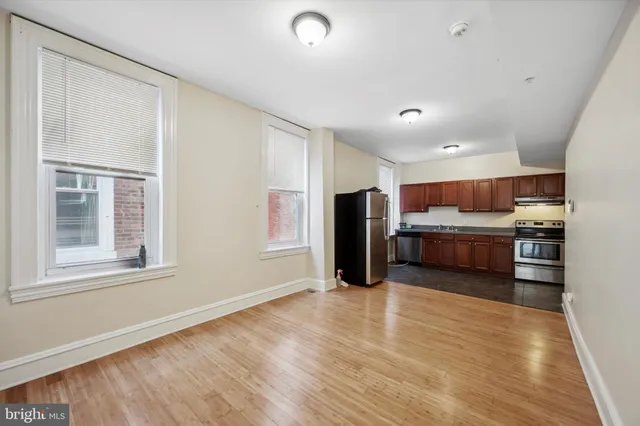 a view of kitchen with refrigerator stove and wooden cabinets