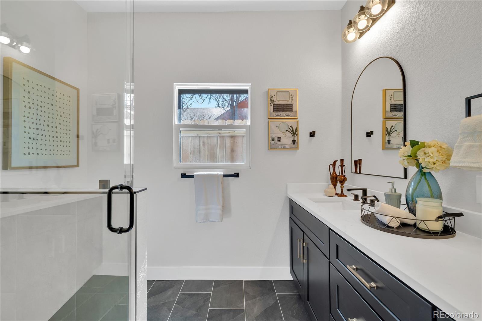 3512 High Street Denver, CO 80205 - Photo 15 of 33 a bathroom with a double vanity sink a toilet and shower