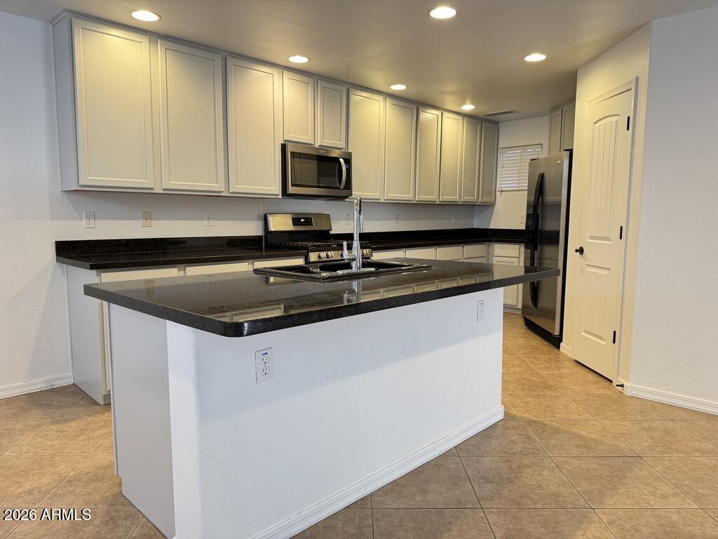 2611 North 48th Street, Unit 4 Phoenix, AZ 85008 - Photo 3 of 23 a kitchen with stainless steel appliances granite countertop a stove a sink and a microwave