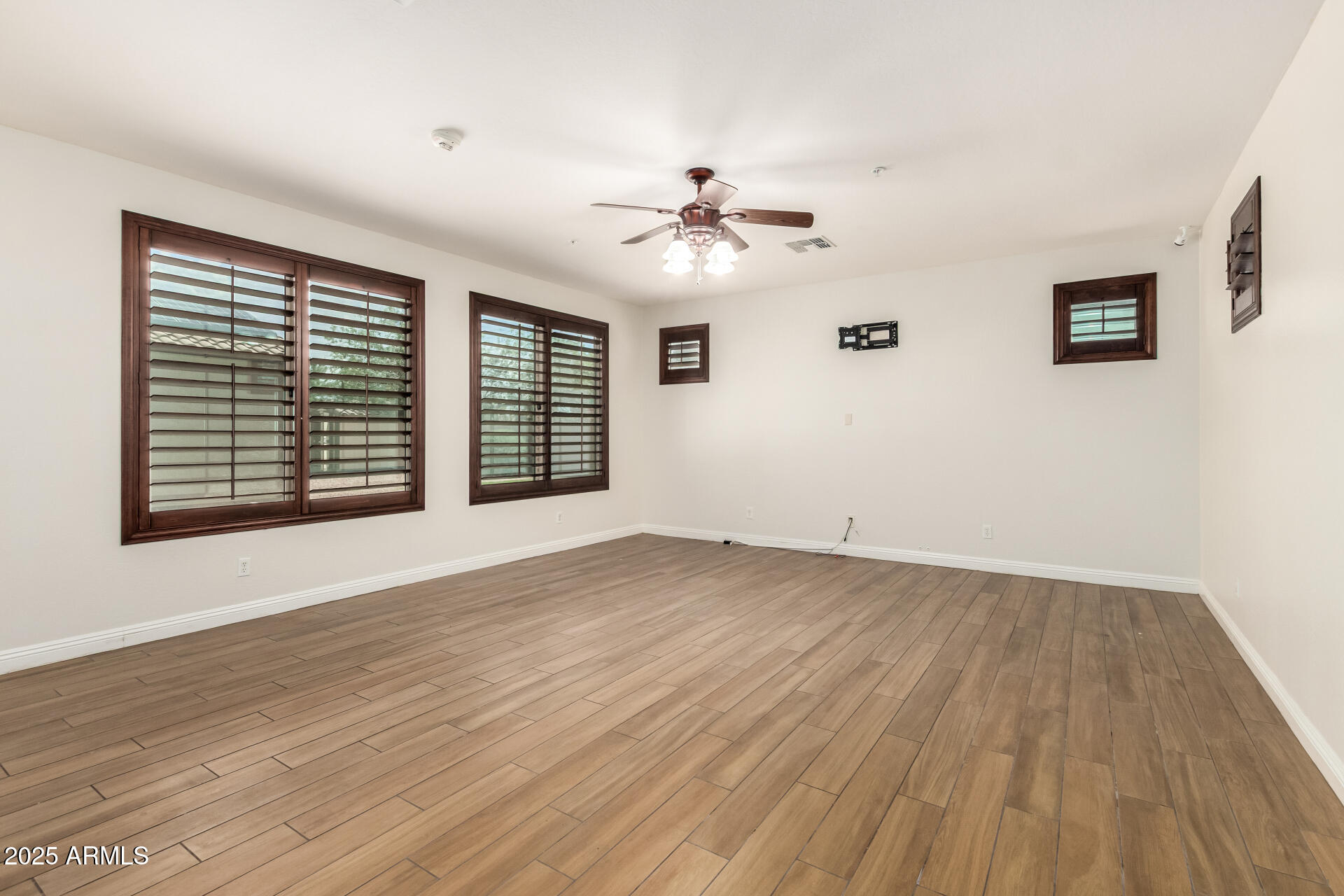 19263 East Estrella Road Queen Creek, AZ 85142 - Photo 15 of 53 a view of an empty room with a window and wooden floor