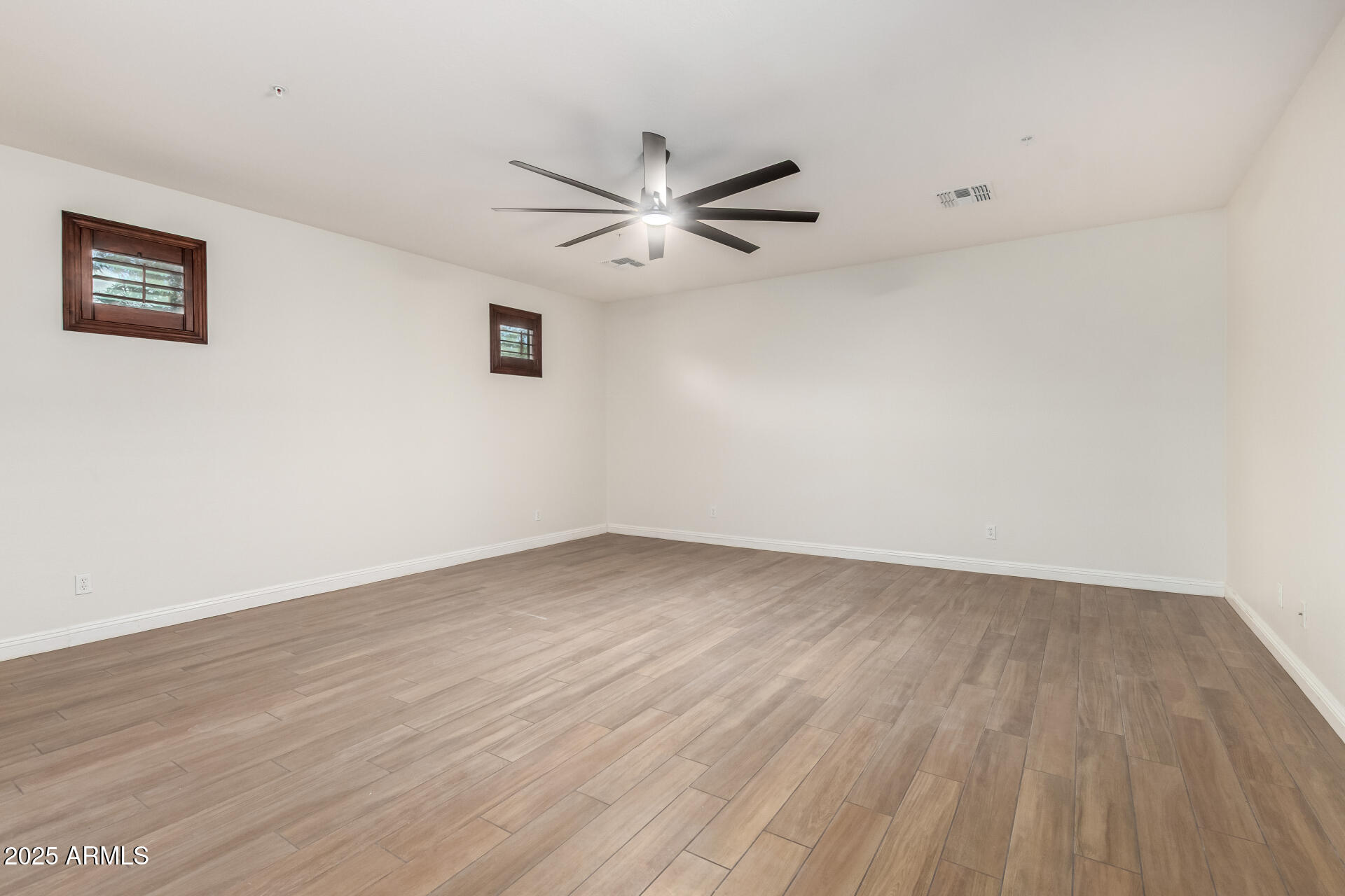 19263 East Estrella Road Queen Creek, AZ 85142 - Photo 17 of 53 an empty room with wooden floor and a ceiling fan