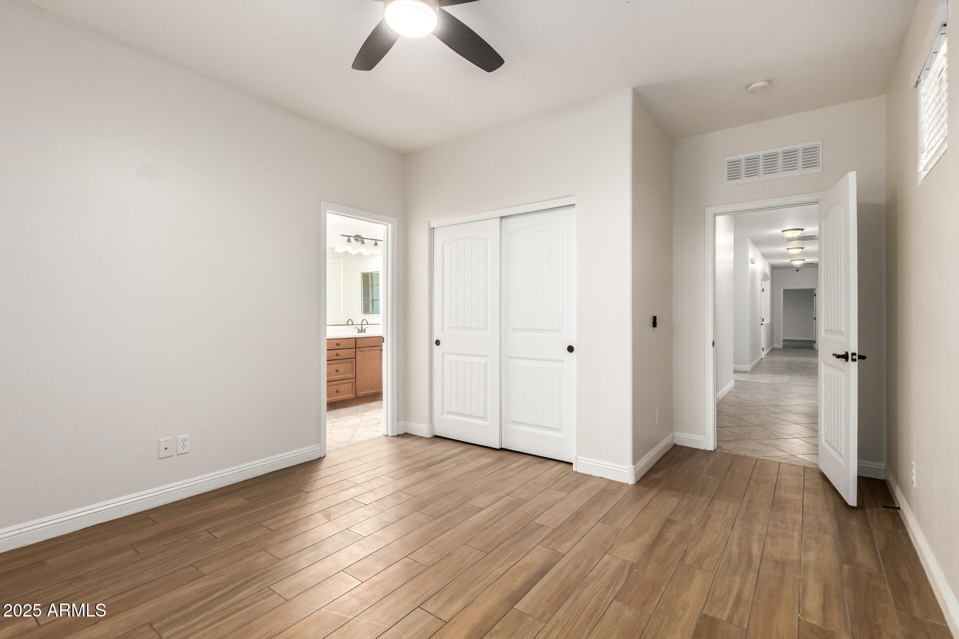 19263 East Estrella Road Queen Creek, AZ 85142 - Photo 30 of 53 an empty room with wooden floor cabinet and a view of bathroom
