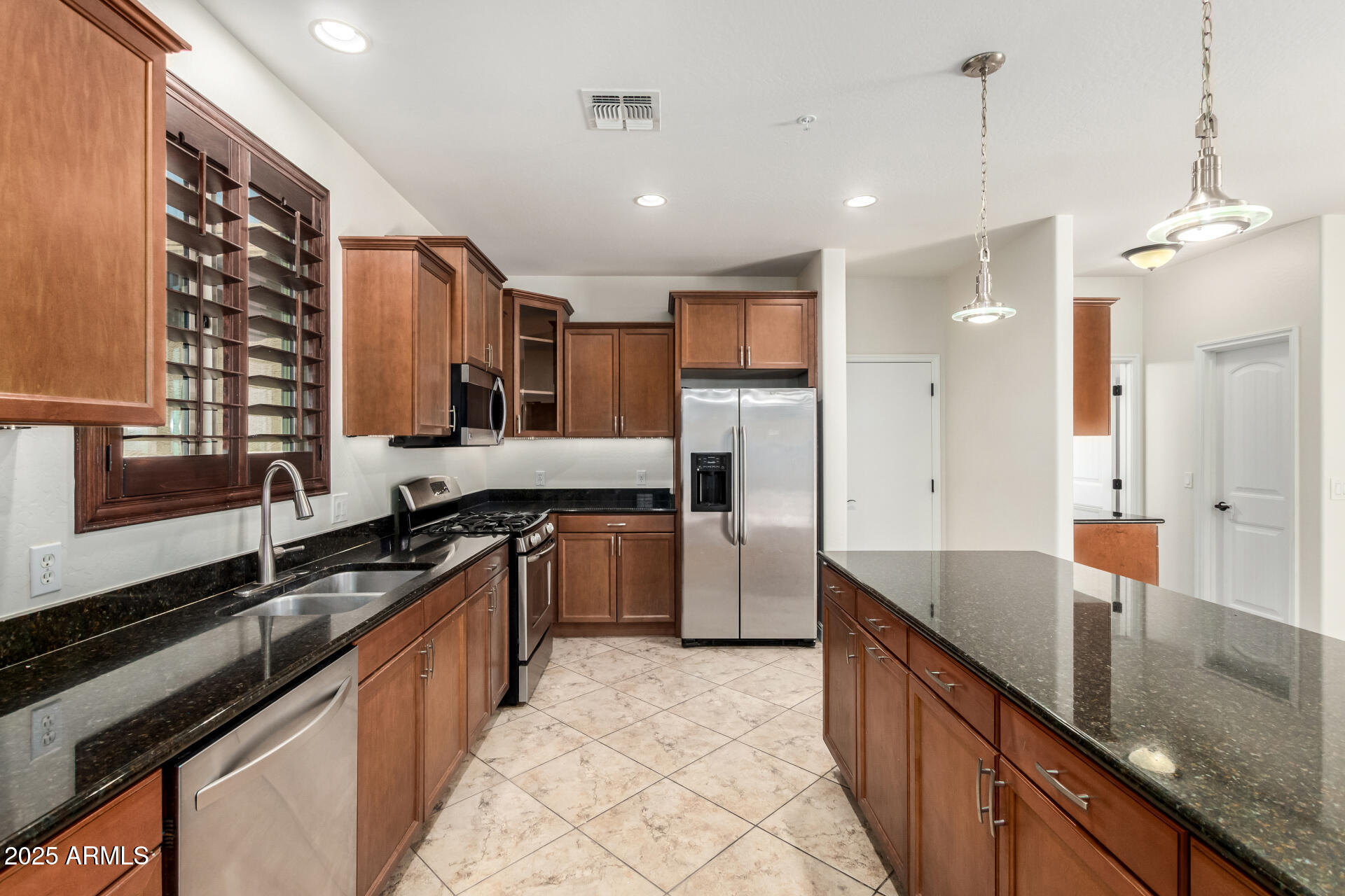 19263 East Estrella Road Queen Creek, AZ 85142 - Photo 8 of 53 a large kitchen with granite countertop a large counter top a sink stainless steel appliances and cabinets