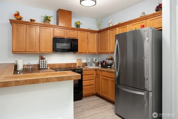 a kitchen with stainless steel appliances granite countertop a refrigerator a stove a sink and a microwave