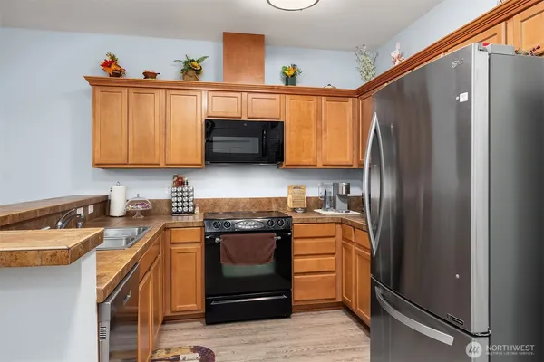 a kitchen with stainless steel appliances granite countertop a stove a sink and a refrigerator