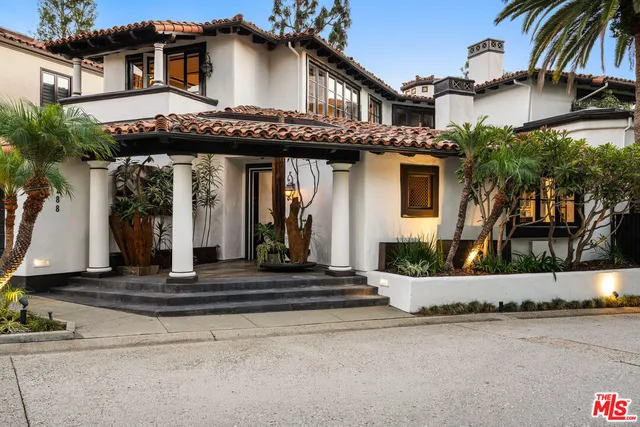 a front view of a house with a garden and plants