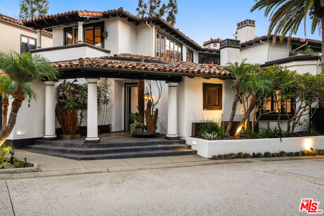 a front view of a house with a garden and plants