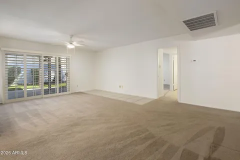 an empty room with a ceiling fan and wooden floor