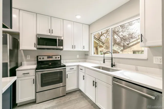 a view of a hallway with wooden floor and cabinets
