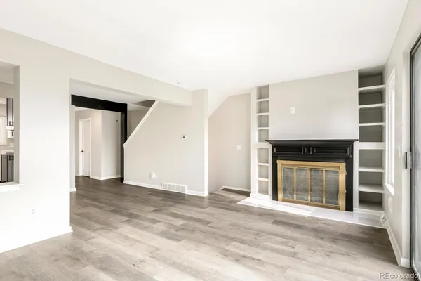 a view of a big room with wooden floor and a kitchen