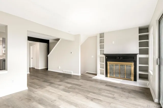 a view of a big room with wooden floor and a kitchen