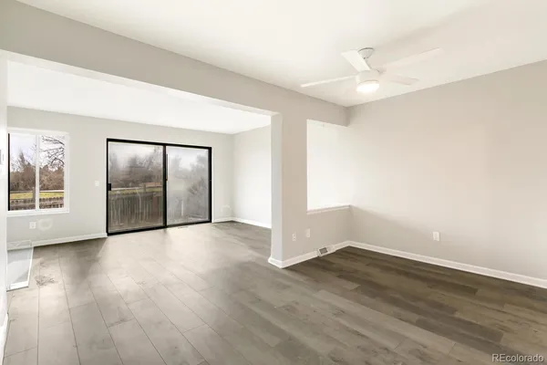 a view of a big room with wooden floor and windows