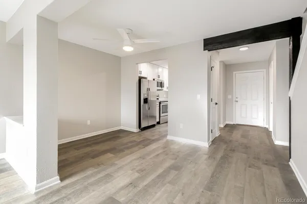 an empty room with wooden floor and a bathroom