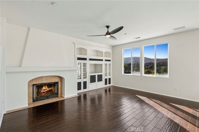 a view of an empty room with a window and fireplace