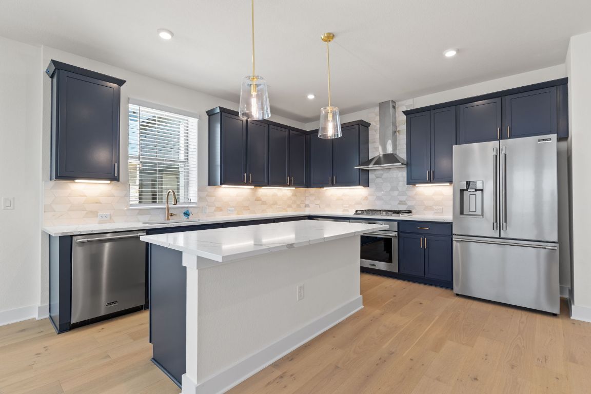 6312 Stockman Drive, Unit 6 Austin, TX 78747 - Photo 3 of 35 a kitchen with kitchen island granite countertop a refrigerator a sink a stove a microwave a center island and furniture