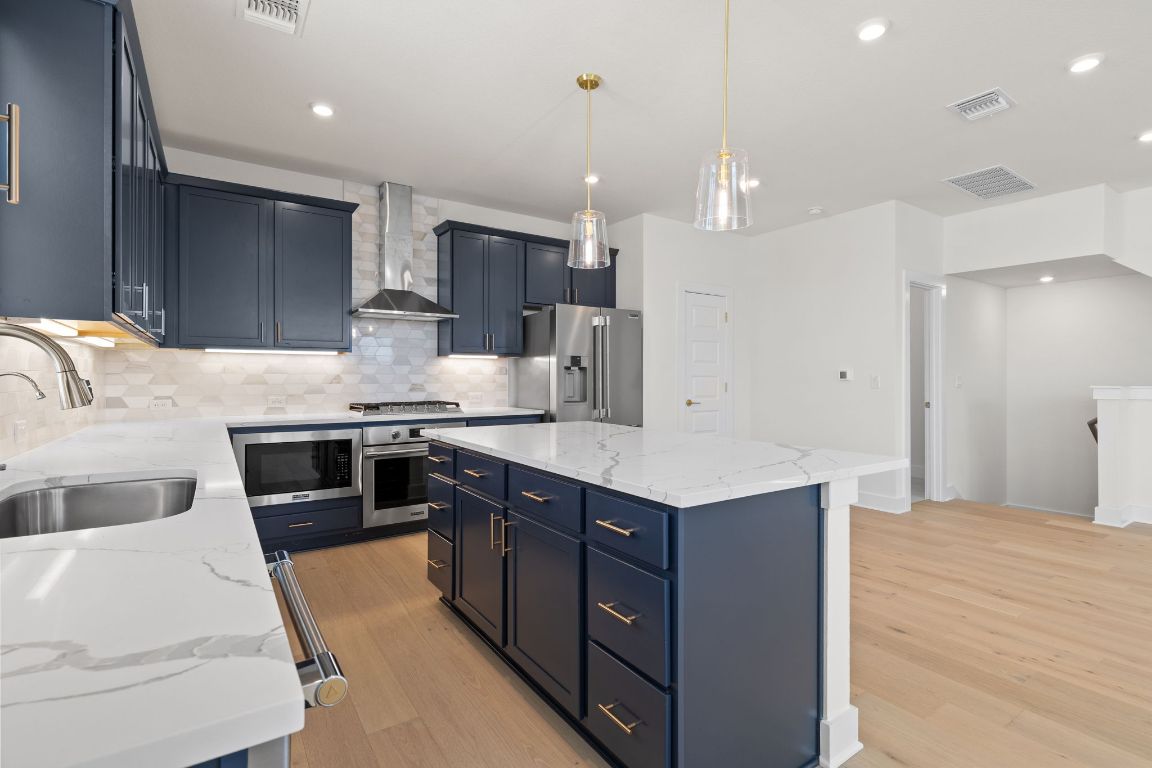 6312 Stockman Drive, Unit 6 Austin, TX 78747 - Photo 5 of 35 a kitchen with kitchen island a sink stainless steel appliances and cabinets