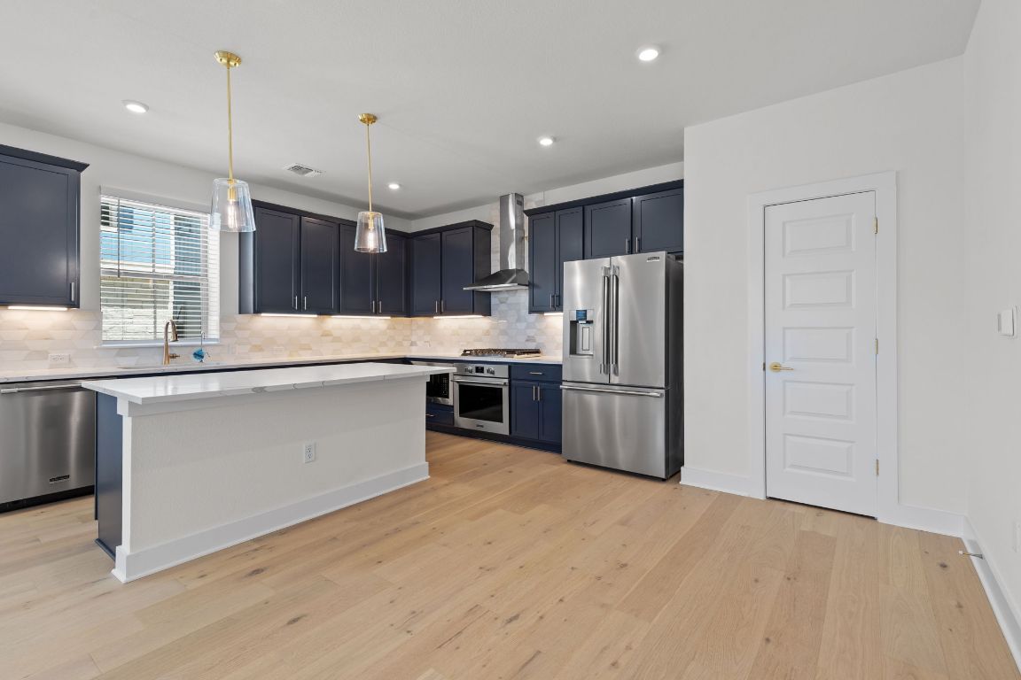 6312 Stockman Drive, Unit 6 Austin, TX 78747 - Photo 6 of 35 a kitchen with stainless steel appliances a refrigerator sink and wooden cabinets