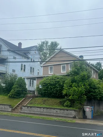 a front view of a house with a yard and potted plants