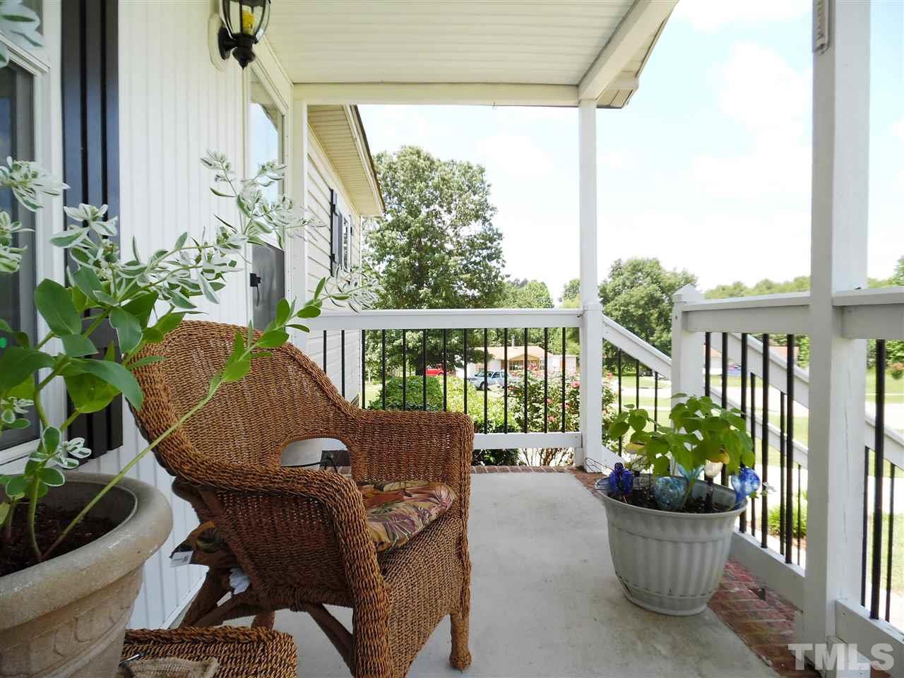 a view of a porch with chairs and potted plants