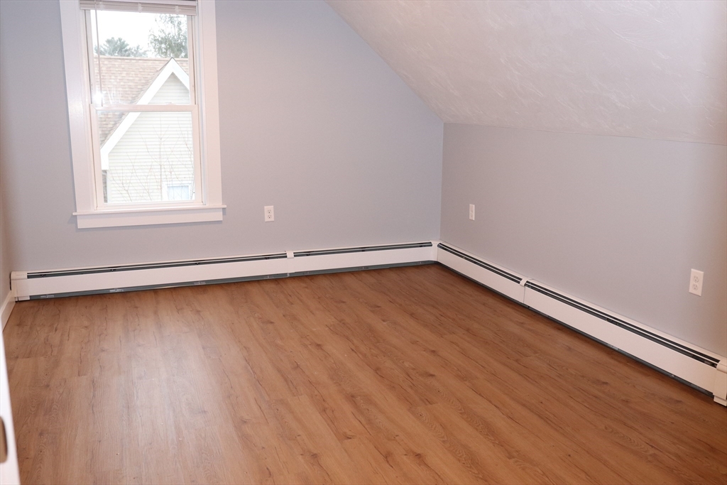 73 Everett Street, Unit 3 Middleboro, MA 02346 - Photo 11 of 17 an empty room with wooden floor and windows