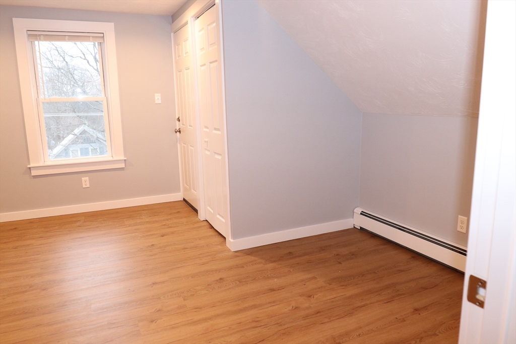 73 Everett Street, Unit 3 Middleboro, MA 02346 - Photo 14 of 17 an empty room with wooden floor and windows