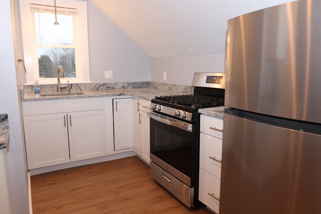 73 Everett Street, Unit 3 Middleboro, MA 02346 - Photo 2 of 17 a kitchen with granite countertop white cabinets and white appliances