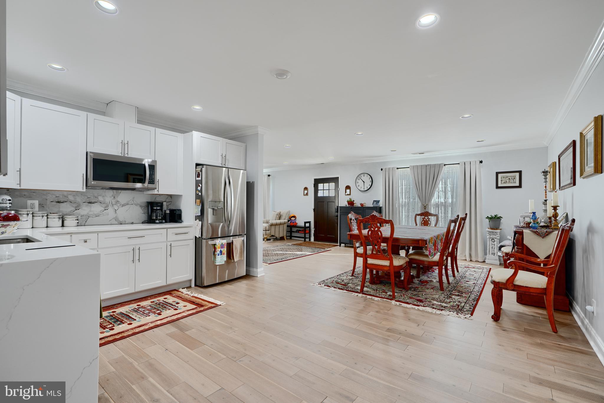 12330 Scaggsville Road Fulton, MD 20759 - Photo 9 of 40 a open kitchen with stainless steel appliances granite countertop a stove top oven a sink dishwasher a dining table and chairs with wooden floor