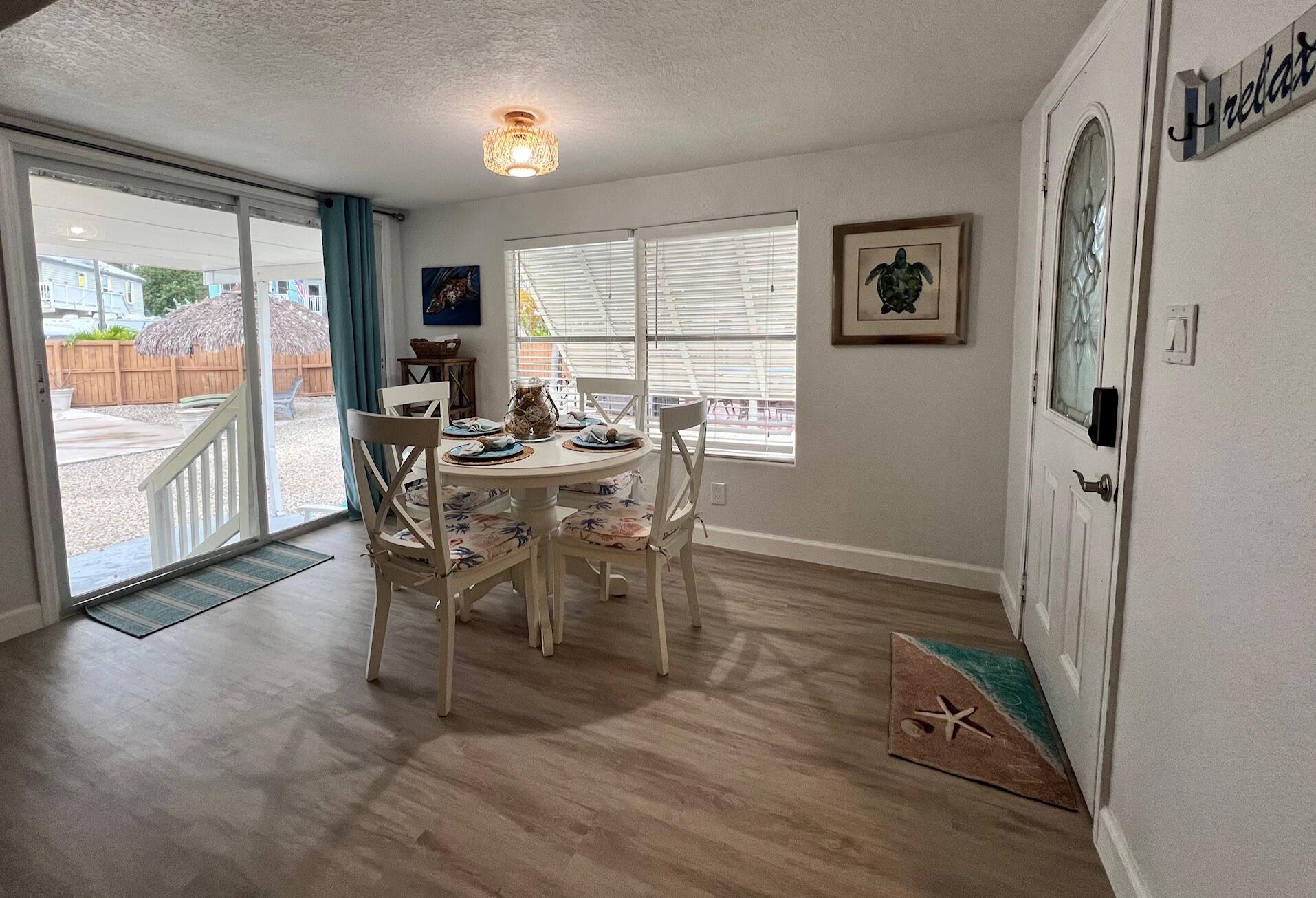 321 Windley Road, Unit B Key Largo, FL 33037 - Photo 3 of 5 a view of a dining room with furniture large window and wooden floor