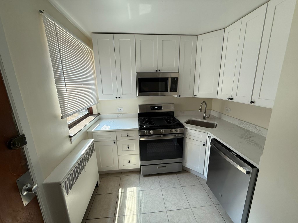 7375 North Winchester Avenue, Unit 1W Chicago, IL 60626 - Photo 2 of 8 a kitchen with a sink stove and cabinets