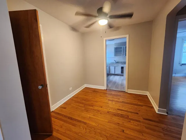 an empty room with wooden floor and closet area