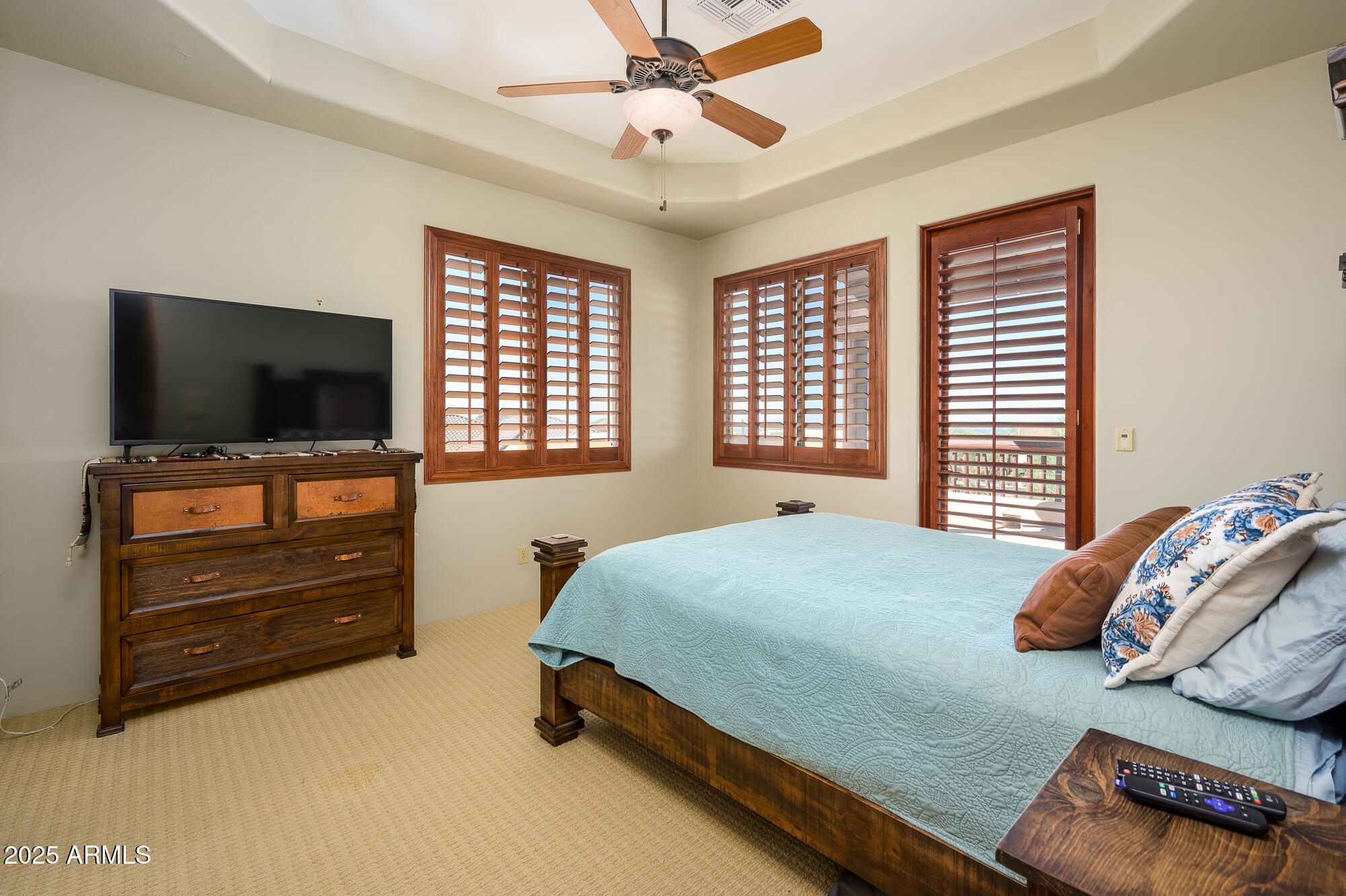 8540 East McDowell Road, Unit 29 Mesa, AZ 85207 - Photo 33 of 59 a bedroom with a bed and a flat tv screen on dresser